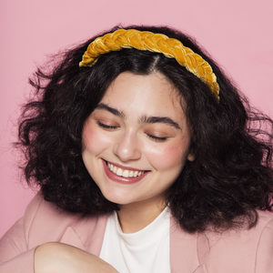 menina morena usando tiara para cabelo trançada amarela