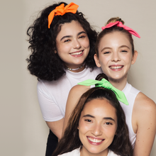 Carregar imagem no visualizador da galeria, tres meninas sorrindo usando xuxinhas de cabelo colorida
