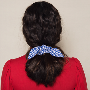 menina morena usando xuxinha para cabelo azul e branca estampa vichy